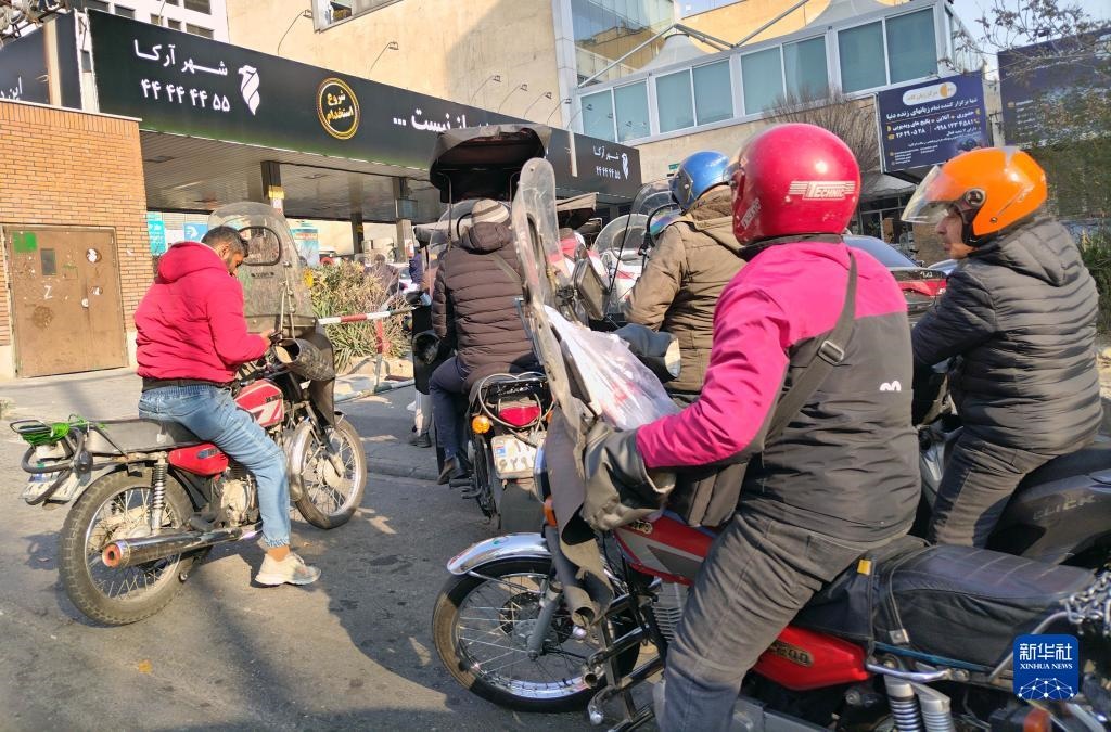 12月18日，摩托車在伊朗首都德黑蘭的一家加油站外等待加油。新華社記者 沙達(dá)提 攝