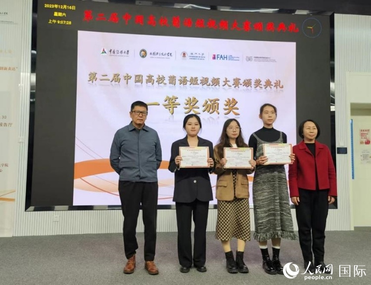 澳門大學中葡雙語教學暨培訓(xùn)中心主任姚京明（左一）和中國傳媒大學外國語言文化學院院長文春英（右一）為一等獎獲得者頒獎。人民網(wǎng)記者 魯揚攝