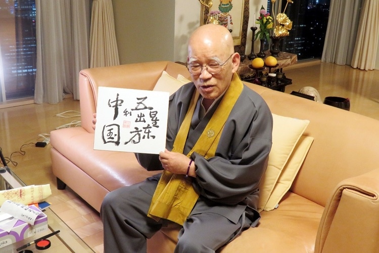 小島康譽(yù)展示自己書(shū)寫(xiě)的“五星出東方利中國(guó)”。視頻截圖