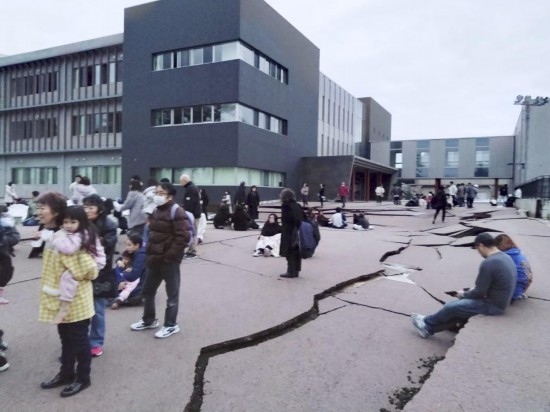  1月1日，在日本石川縣輪島市，人們站在被地震破壞的地面上。新華社/共同社
