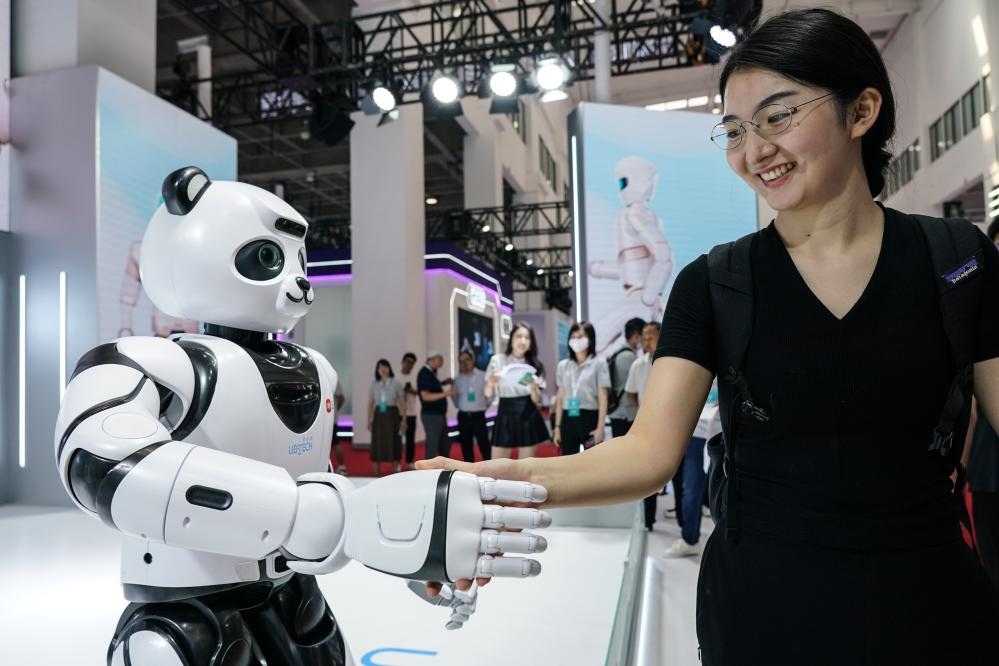 2023年8月16日，一名女士在北京舉辦的2023世界機器人大會現(xiàn)場與智能機器人握手。新華社記者彭子洋攝