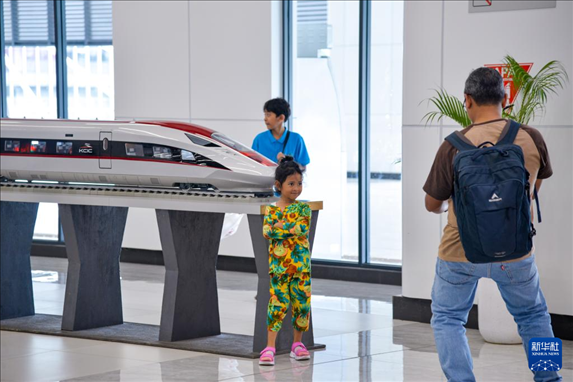 1月24日，在印度尼西亞雅加達(dá)哈利姆站候車大廳，一名小朋友和雅萬高鐵高速動車組模型合影。新華社記者 徐欽 攝