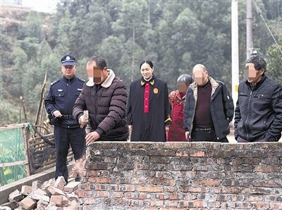  圖③：庭審結(jié)束后，在法官的見證下，陳某在院壩邊重新開鑿一條通道。