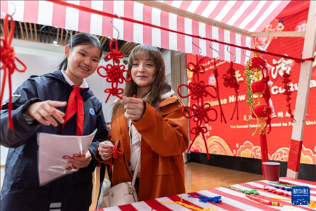 1月28日，復旦大學第二附屬學校學生（左）為美國馬斯卡廷中學學生（右）介紹中國結。 新華社記者 王翔 攝
