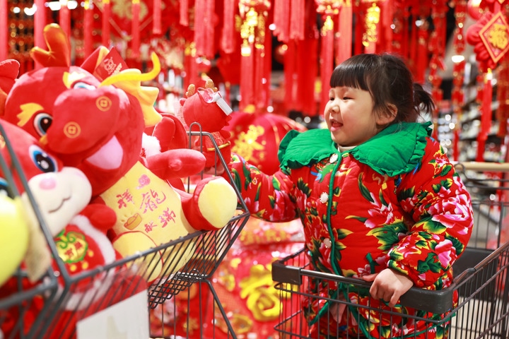 1月23日，在貴州省黔東南苗族侗族自治州岑鞏縣一家超市，小朋友在家人的帶領(lǐng)下選購龍年毛絨玩具。新華社發(fā)（唐鵬攝）