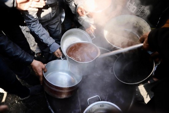  2月27日，在加沙地帶北部的杰巴利耶難民營(yíng)，人們領(lǐng)取食物。新華社發(fā)（穆罕默德·阿里攝）