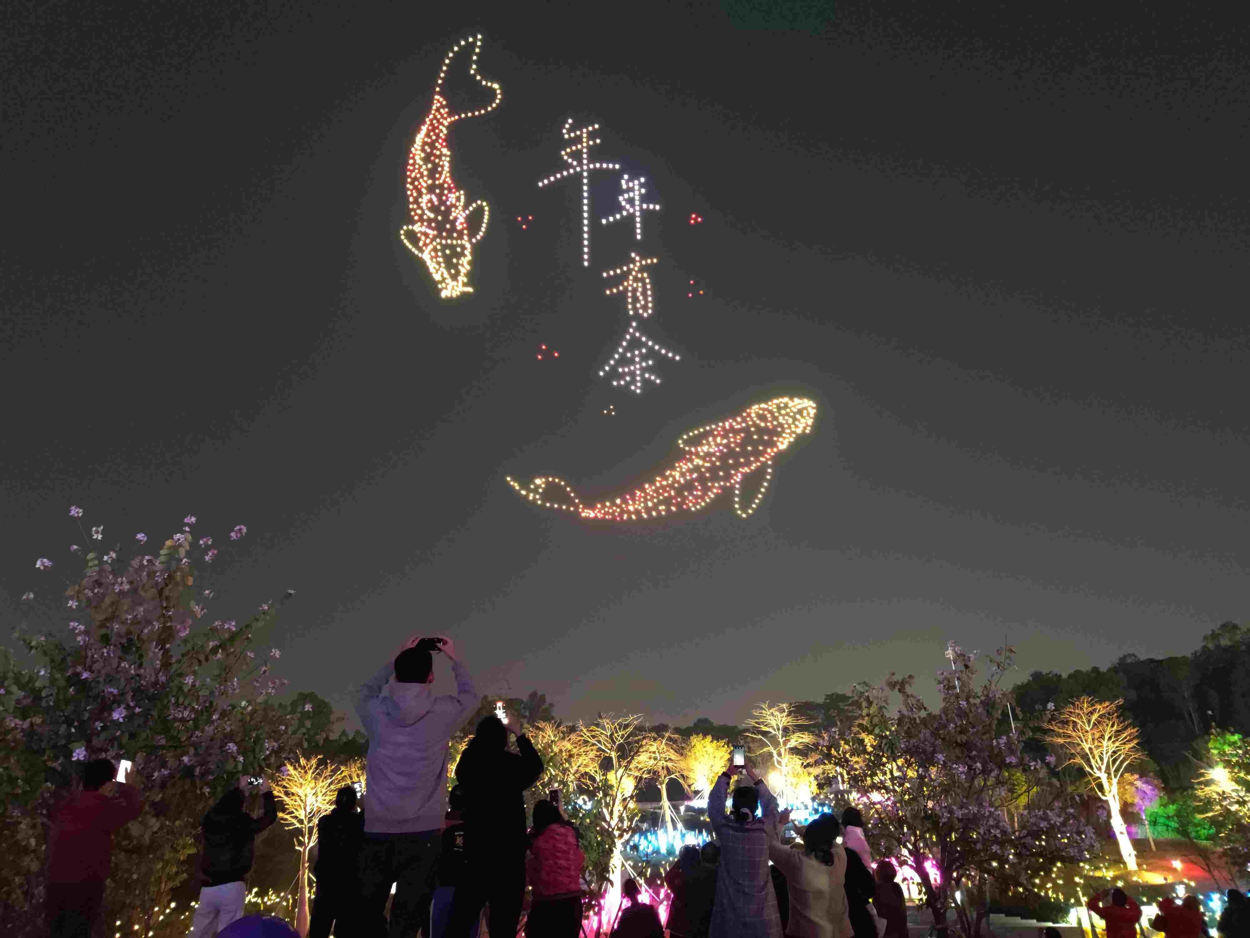 △ 2024年2月10日，深圳北站中心公園，春節(jié)主題無人機(jī)燈光秀引來眾多游客駐足觀看。