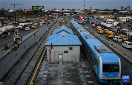 3月4日，在尼日利亞拉各斯，一列輕軌藍(lán)線列車行駛至公路交通擁堵路段附近。新華社記者 韓旭 攝