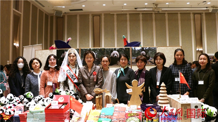 中國駐日本大使吳江浩夫人丁玥（左五）與使館人員在展位前合影留念。人民網(wǎng) 許可攝