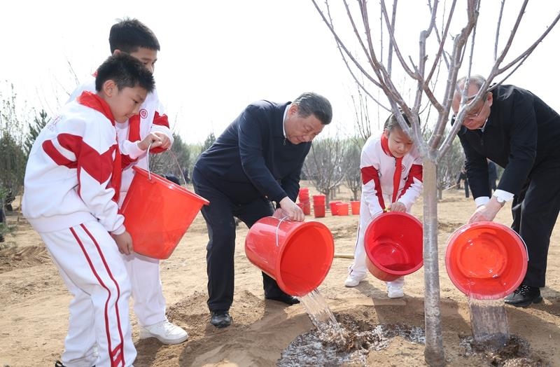 2024年4月3日，習(xí)近平總書(shū)記同少先隊(duì)員一起給剛栽下的樹(shù)苗澆水。