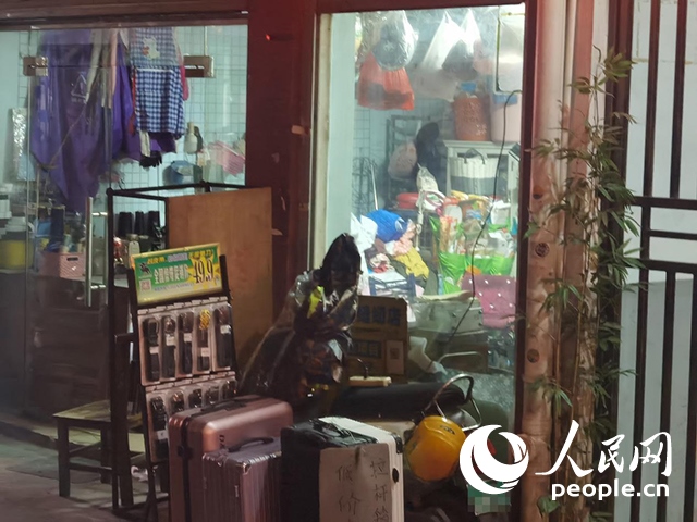 南寧“城中村”一裁縫鋪老板將電線從店內(nèi)拉出為電動(dòng)自行車充電。人民網(wǎng) 覃心攝