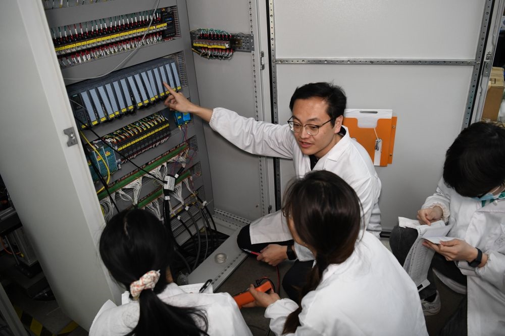 2024年4月6日，在位于安徽合肥的中國科學(xué)技術(shù)大學(xué)，安徽省先進(jìn)功能高分子薄膜工程實(shí)驗(yàn)室團(tuán)隊(duì)成員在檢修自主研制的高分子薄膜原位雙向拉伸實(shí)驗(yàn)設(shè)備的電氣控制系統(tǒng)。
