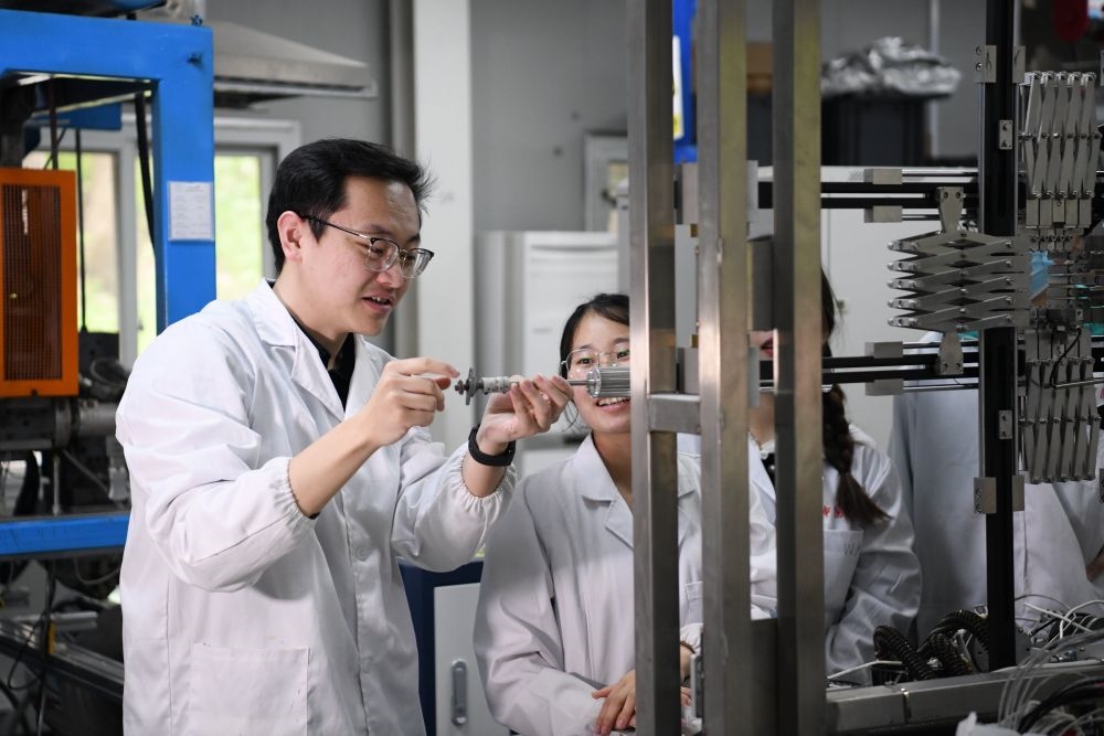 2024年4月6日，在位于安徽合肥的中國科學(xué)技術(shù)大學(xué)，安徽省先進(jìn)功能高分子薄膜工程實(shí)驗(yàn)室團(tuán)隊(duì)成員朱健和（左）在和同事討論實(shí)驗(yàn)設(shè)備的設(shè)計方案。