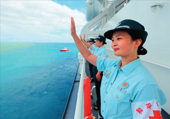 中國海軍“和平方舟”號醫(yī)院船結(jié)束訪問湯加時，任務(wù)官兵中的文職人員向歡送人群揮手告別（2023年8月4日攝）。徐巍攝/本刊