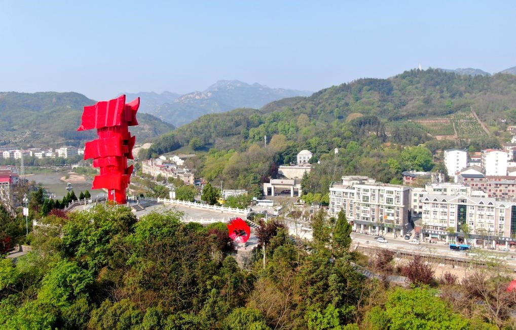 這是2021年4月9日拍攝的鄂豫皖蘇區(qū)首府革命博物館附近的英雄山上的“紅旗飄飄”主題雕塑（無人機(jī)照片）。新華社發(fā)