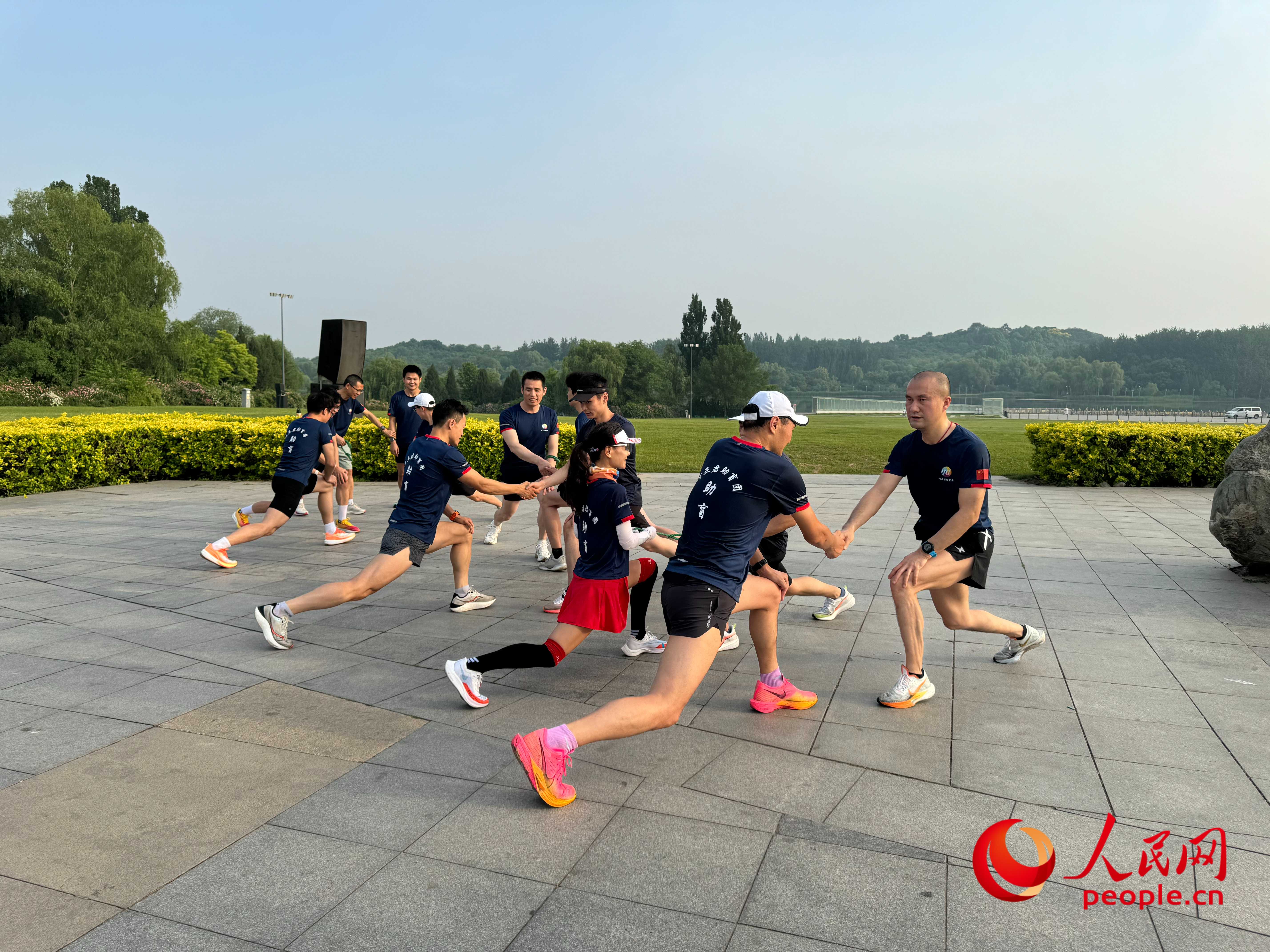 盲人和志愿者做跑步前準(zhǔn)備。人民網(wǎng) 周靜圓攝