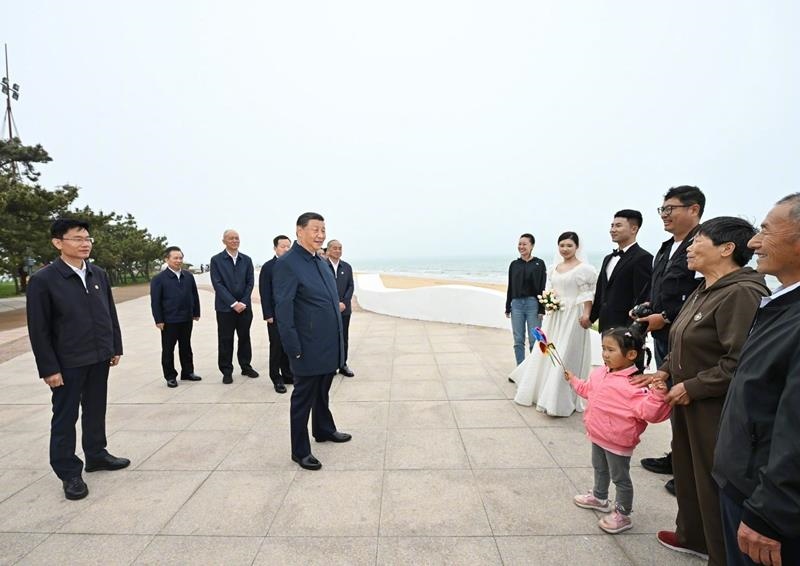 5月22日，在山東日照考察調(diào)研的習(xí)近平總書記來到陽光海岸綠道，同市民游客親切交流。