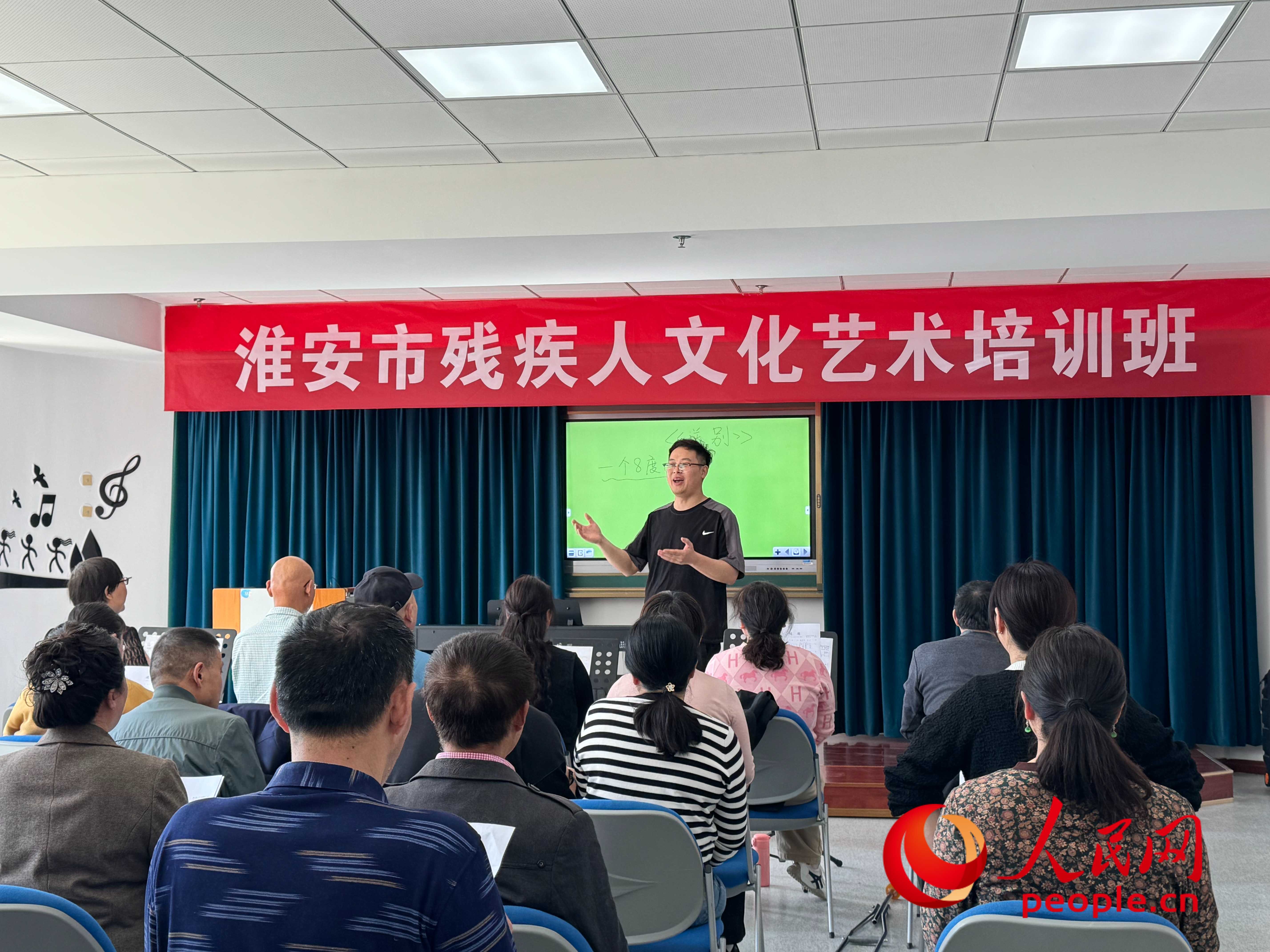在淮安市殘疾人文化藝術(shù)培訓(xùn)班上，聲樂老師在教殘疾人唱《送別》這首歌曲。人民網(wǎng) 周靜圓攝