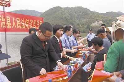 法院干警及相關(guān)部門工作人員對群眾進(jìn)行生態(tài)環(huán)境保護(hù)普法教育。