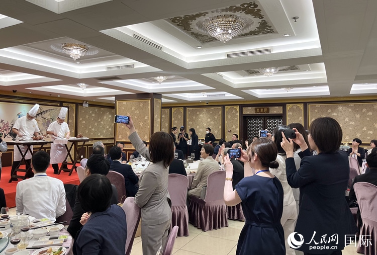 國家級非物質(zhì)文化遺產(chǎn)、全聚德片鴨工藝吸引代表團(tuán)成員拍照留念。