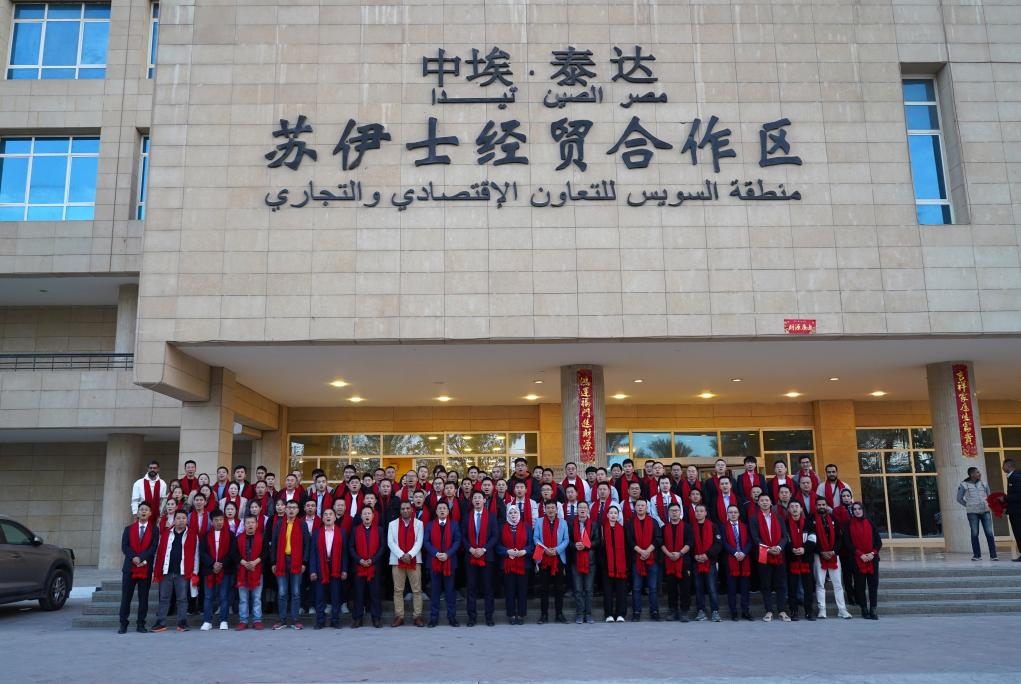 2024年2月11日，在位于埃及蘇伊士省的中?！ぬ┻_(dá)蘇伊士經(jīng)貿(mào)合作區(qū)，中埃員工在合作區(qū)辦公大樓前合影拜年。新華社發(fā)（泰達(dá)合作區(qū)供圖）
