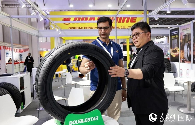 工作人員向客戶展示雙星電動汽車輪胎。和傳統(tǒng)汽車輪胎相比，電動汽車輪胎具有更高承載能力、更加靜音舒適、更好極速抓地、更低滾動阻力等特點。人民網(wǎng)記者 管克江攝