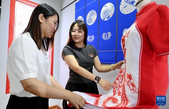 5月31日，在衡水市阜城縣一家剪紙工作室，游客在觀賞帶有剪紙元素的旗袍。