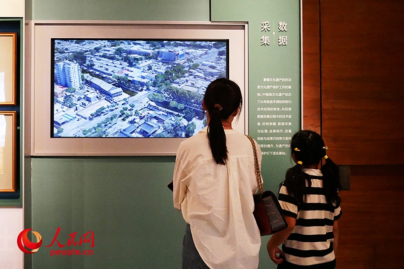 家長(zhǎng)正在帶孩子參觀“輝煌中軸”專題展。人民網(wǎng)記者 韋衍行攝