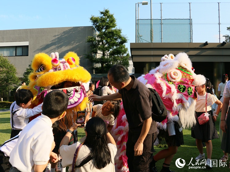 孩子們好奇地圍觀舞獅。人民網(wǎng) 許可攝