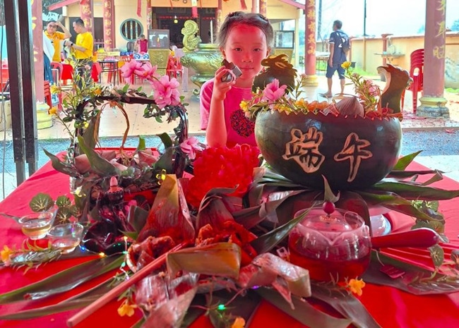 小朋友展示學裹粽子的成品照。組委會供圖