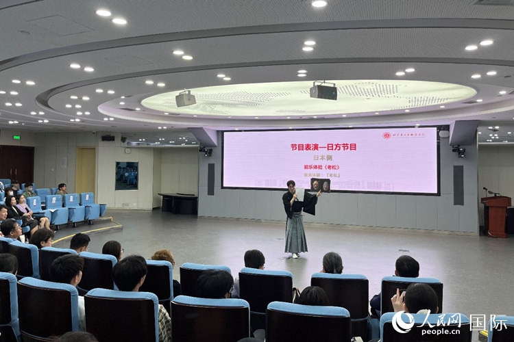 日本大學(xué)生介紹能樂知識(shí)。人民網(wǎng)記者 陳思攝