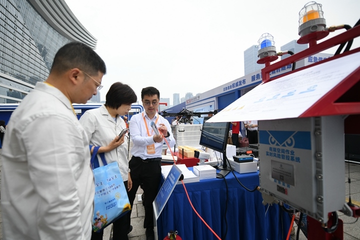 6月16日，在全國“安全宣傳咨詢?nèi)铡敝鲌龌顒?dòng)上，四川省安全科學(xué)技術(shù)研究院工作人員（右一）向參觀者介紹“有限空間作業(yè)實(shí)時(shí)風(fēng)險(xiǎn)管控系統(tǒng)”。新華社記者胥冰潔攝