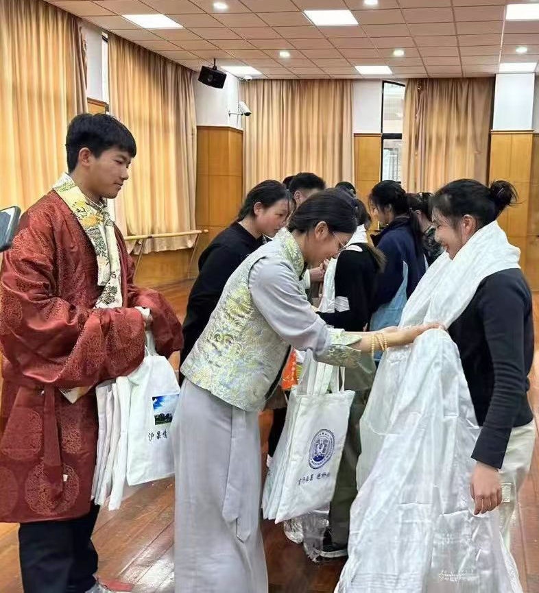 2024年1月18日，在上海市大同中學(xué)，果洛西寧民族中學(xué)學(xué)生給上海大同中學(xué)師生獻哈達。新華社發(fā)（果洛州教育局供圖）