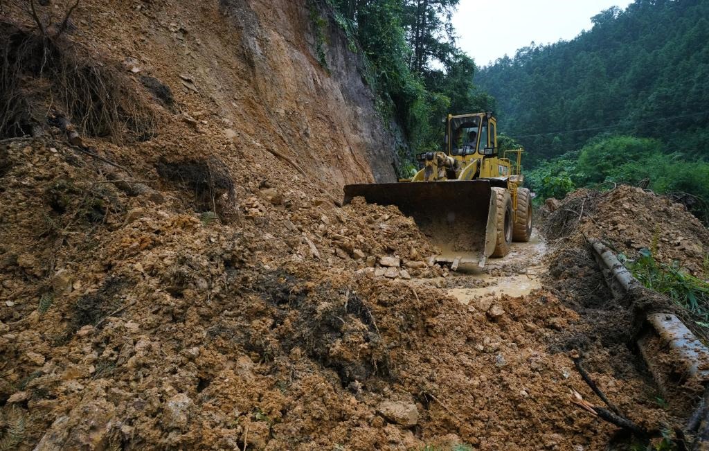 6月18日，在廣西融水苗族自治縣融水鎮(zhèn)新安村，一臺推土機在清理塌方路段。新華社發(fā)（龍林智攝）