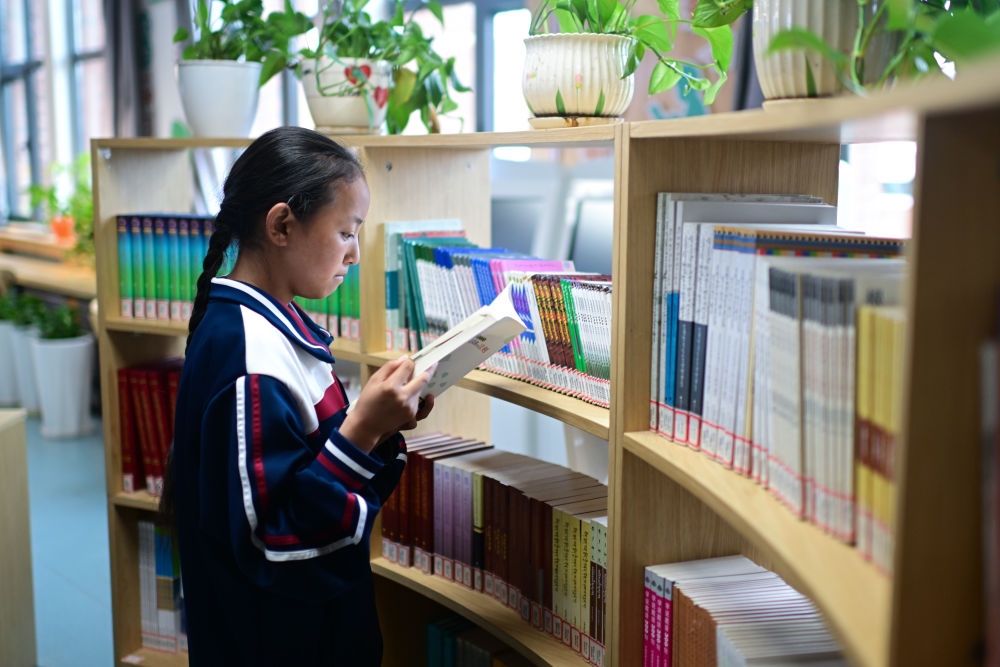 6月18日，果洛西寧民族中學(xué)學(xué)生尼東拉毛在圖書室看書。