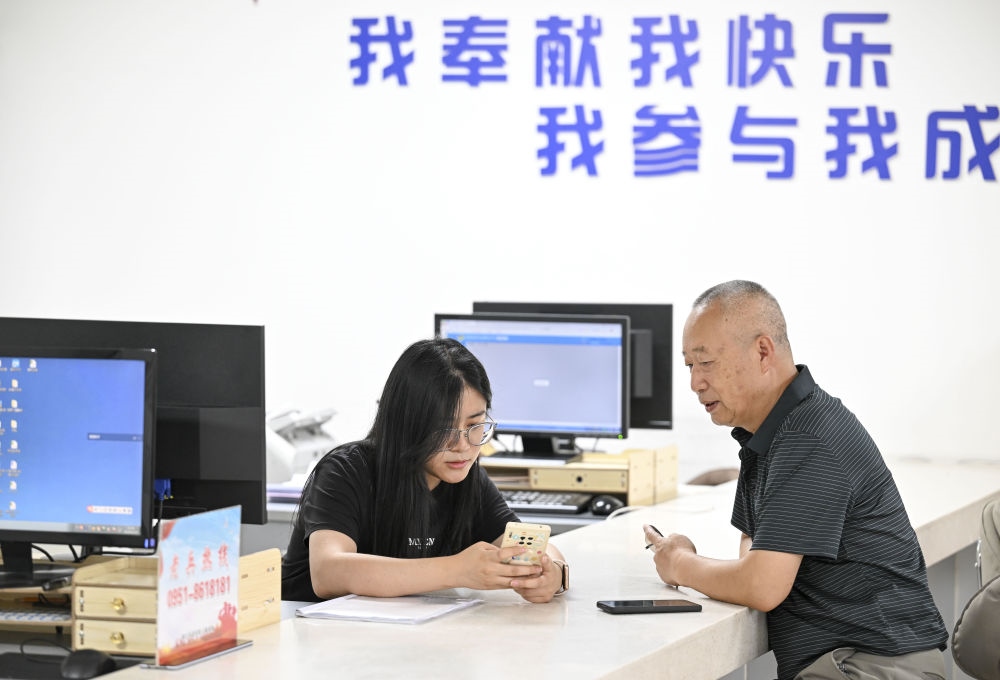 6月20日，在長(zhǎng)城花園社區(qū)黨群服務(wù)中心，工作人員幫助居民辦理業(yè)務(wù)。