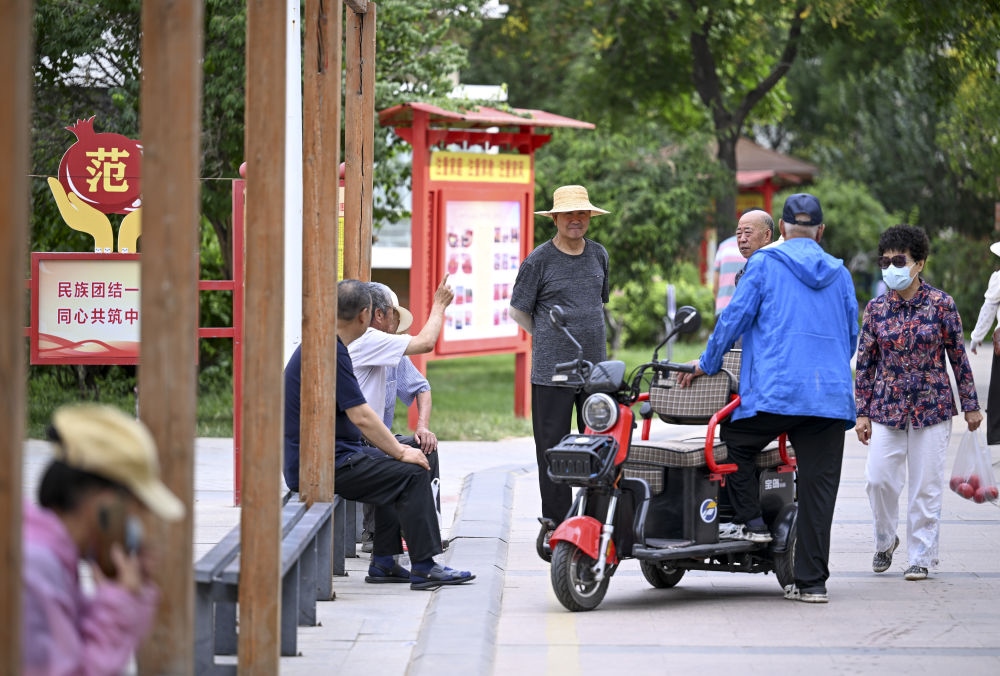 6月20日，長(zhǎng)城花園社區(qū)的居民在休閑、聊天。
