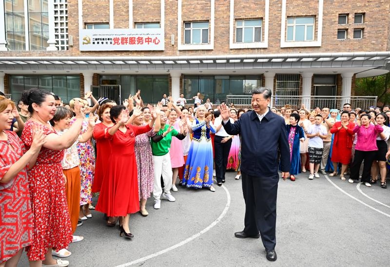 2022年7月13日，習(xí)近平總書記在新疆烏魯木齊市天山區(qū)固原巷社區(qū)考察時(shí)，向各族群眾揮手致意。