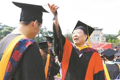 2017年6月22日，李德仁（右一）參加武漢大學畢業(yè)典禮并為畢業(yè)生撥穗。