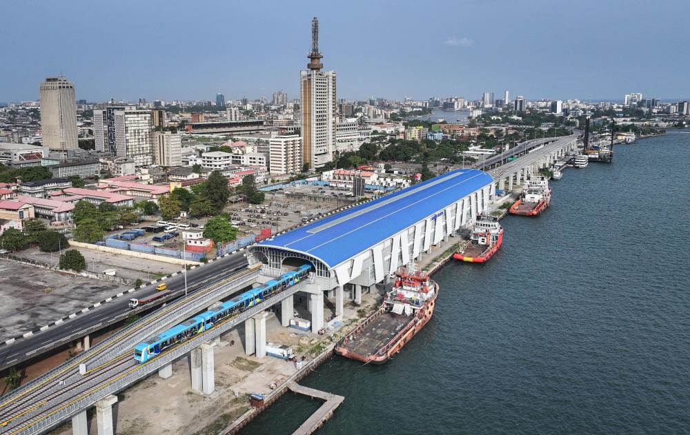2024年3月2日，在尼日利亞拉各斯，一列輕軌藍(lán)線列車駛?cè)氪a頭站（無人機(jī)照片）。拉各斯輕軌藍(lán)線是西非地區(qū)首條由中國企業(yè)自主設(shè)計、建造、施工、運(yùn)營的電氣化城市軌道交通項(xiàng)目。新華社記者 韓旭 攝