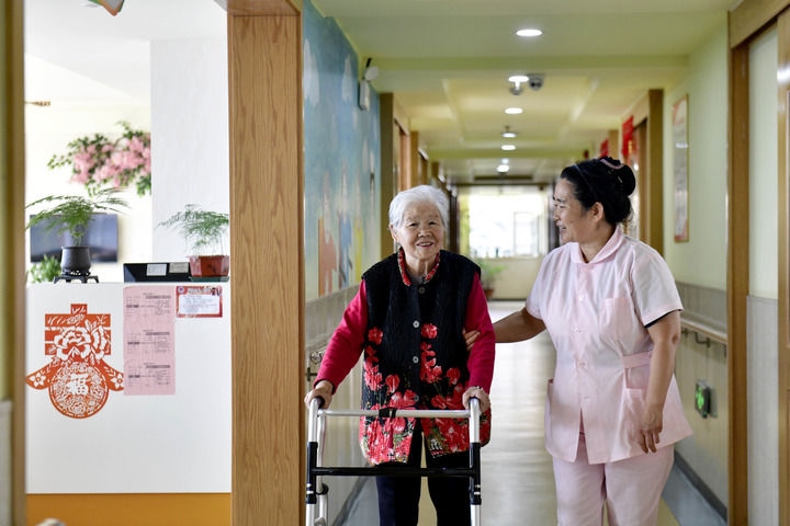 2024年5月25日，在山東省日照市東港區(qū)石臼街道日照幸福護(hù)理院，工作人員在陪護(hù)老人。新華社記者 郭緒雷 攝