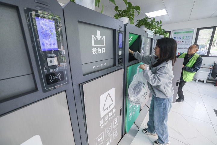 2024年4月10日，在浙江省湖州市吳興區(qū)飛英街道新華府小區(qū)內(nèi)，居民在垃圾分類智能系統(tǒng)的指導(dǎo)下進(jìn)行垃圾分類投放，居民的投放情況將實(shí)時(shí)匯總到智慧服務(wù)平臺(tái)，會(huì)有相應(yīng)的積分獎(jiǎng)勵(lì)。新華社記者 徐昱 攝