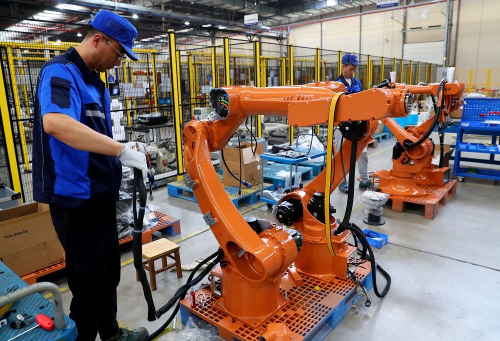 工作人員在上海新時(shí)達(dá)機(jī)器人有限公司位于嘉定的智能工廠內(nèi)忙碌（2024年5月23日攝）。新華社記者 龔兵 攝