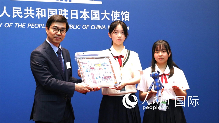 日本小大使向中國駐日本大使館臨時代辦施泳贈送當(dāng)?shù)靥厣Y品。人民網(wǎng) 許可攝