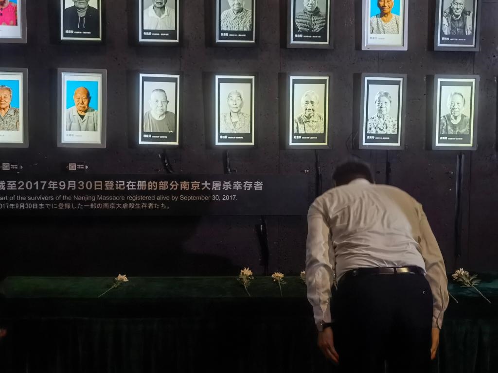 7月18日，人們向離世的南京大屠殺幸存者獻(xiàn)花、鞠躬。新華社記者邱冰清 攝