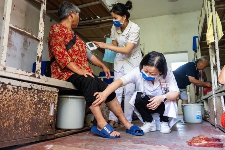 2024年7月30日，在湖南省湘潭縣河口中學(xué)安置點(diǎn)，醫(yī)務(wù)人員為受洪水影響而轉(zhuǎn)移安置的群眾檢查身體。 新華社記者 陳思汗 攝