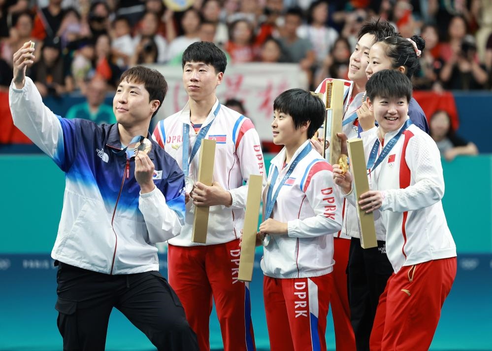 冠軍中國組合王楚欽（右三）/孫穎莎（右一）、亞軍朝鮮組合李正植（左二）/金琴英（左三）、季軍韓國組合林鐘勛（左一）/申裕斌在巴黎奧運(yùn)會(huì)乒乓球混雙頒獎(jiǎng)儀式上合影（2024年7月30日攝）。新華社記者 劉續(xù) 攝