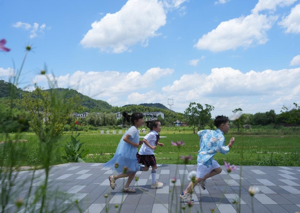 兒童在余姚市梁弄鎮(zhèn)的田野間奔跑（7月3日攝）。新華社記者翁忻旸 攝