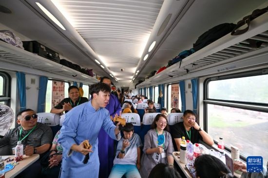 9月7日，相聲演員在S910列車上為旅客表演快板。