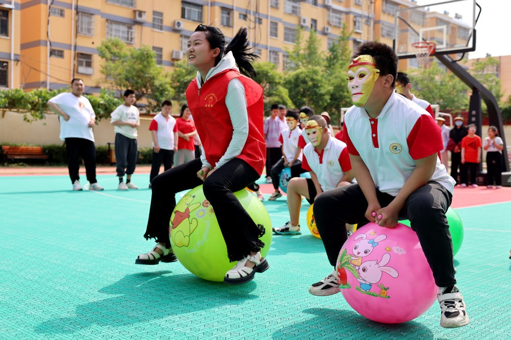 2024年5月17日，在山東省棗莊市市中區(qū)特殊教育中心，青年志愿者與智力障礙學(xué)生一起做游戲。新華社發(fā)（孫中喆攝）